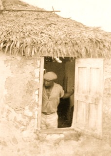 Man standing at door of house, looking out, possibly from the visit by Alan Lomax and Mary Elizabeth Barnacle to Cat Island in the Bahamas 1935