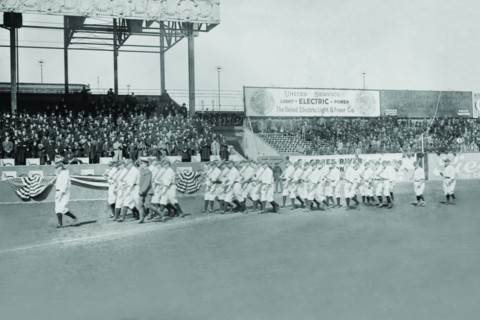 New York Yankees show support for the Troops in World War I by marching around the stadium on baseball uniforms and carrying rifles over their shoulders. 1917