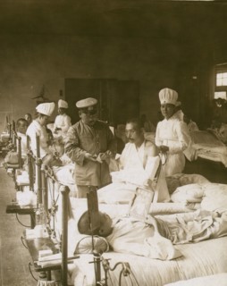 Nurses and a doctor attending wounded soldiers on a hospital ward 1905