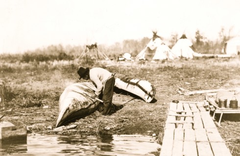 Mending his canoe 1913