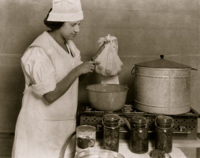 One of the Cabel County Demonstration Team demonstrating the process of blanching tomatoes to visitors at the 4 H Club Fair.  1921