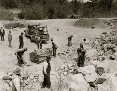 Prisoners breaking up rocks at a prison camp or road construction site 1941