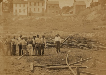 Railroad construction workers straightening track 1863