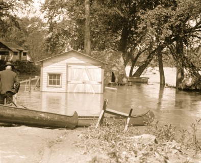 River overflows into garage; canoes set on the banks 1924