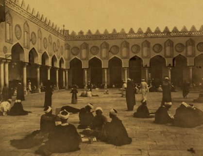 Several groups of theologians, many seated, some writing, in the courtyard of the al-Azhar Mosque. 1880