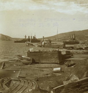 Small boats on shore and warships in harbor at Port Arthur 1905