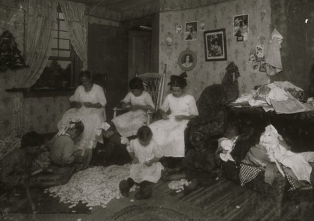 Stringing wooden buttons in a crowded home, Williamsburg,  1912