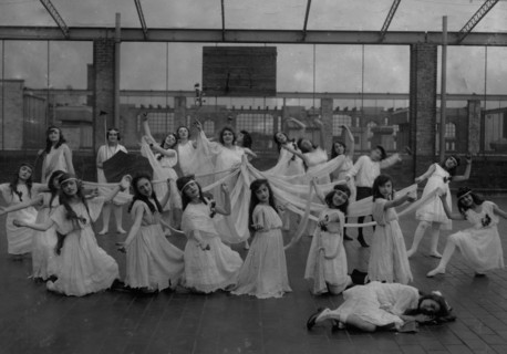 The dance of the Children of the Sunshine with Ellen sleeping in the foreground. Miss Mackay's Pageant Children of Sunshine and Shadow as presented at Washington Irving High School. 1916