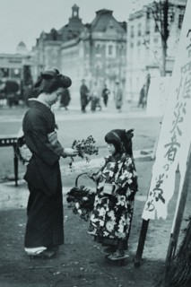 Toddler in front of Shop sign sells flowers to a kimono wearing young lady