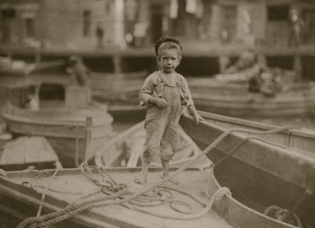 Truant hanging around boats in the harbor during school hours. 1909