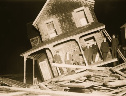 Wrecked Cottage at Seabright with men on tilted front Porch