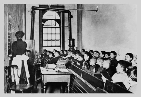 Teacher Instructs Students from Blackboard in Classroom 1890