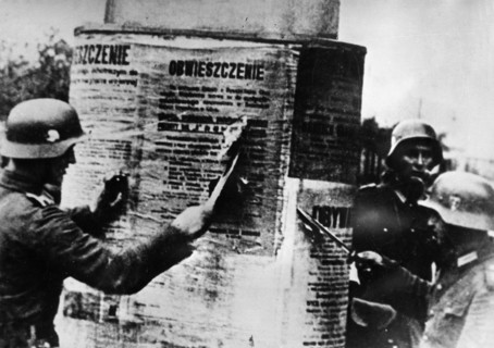 Nazi invasion of poland, september 1939, german soldiers tearing down a polish proclamation, world war 2.