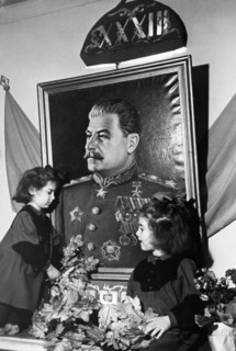 Two young girls at a kindergarten in the sverdlov district of moscow adorning a portrait of joseph stalin with greenery on the eve of the 33rd anniversary of the great october socialist revolution, no...