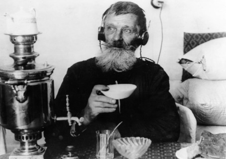 A worker of the 'sibir' match factory with a radio set, drinking tea from his samovar, near tomsk, sibeia, 1928.