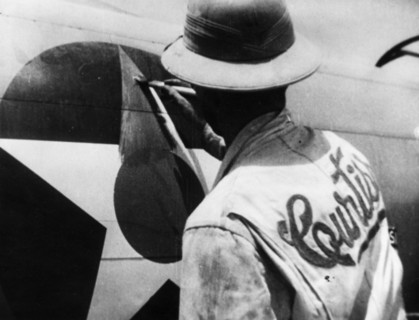 World war 2, lend-lease, a man painting out the american insignia with red paint for delivery of the plane to russia, iran.