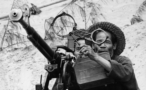Two old fishermen from the village of nam ngan (or donghang) manning an anti-aircraft machine gun to defend against american air attacks, north vietnam, 1968.