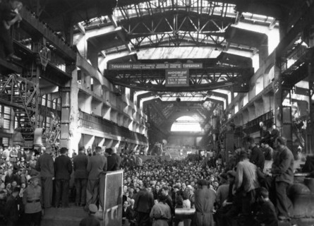 A post-war meeting of workers at the kirov factory discussing plans for production necessary to complete the five-year-plan in four, this factory has been decorated three times, leningrad, ussr, 1946.