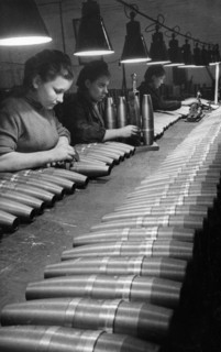 Soviet artillery shells undergoing quality control inspection by civilian women workers at a munitions plant during world war2.
