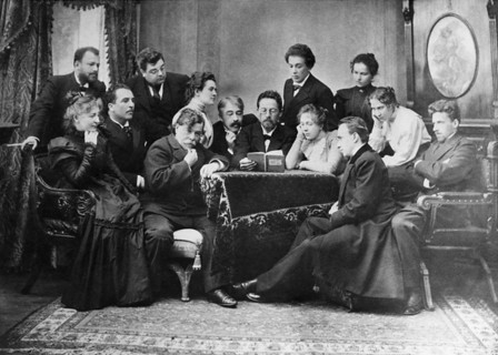 Anton chekhov reads his play 'the seagull' to actors of the moscow art theatre, 1899, chekhov center with book in hand, director and actor konstantin stanislavsky to his left, standing beside stanisla...