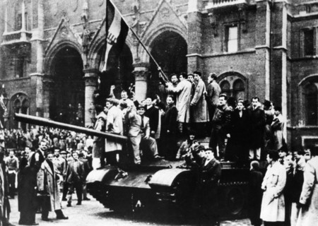 Hungarian uprising, jubilant insurgents outside the hungarian parliament building waving the national hungarian flag from an hungarian army tank in budapest, hungary, october 1956.