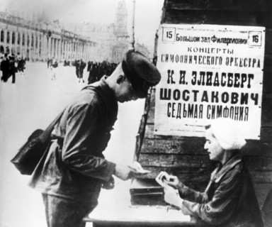 The billboard of the performing of the seventh symphony by d, shostakovich, a soviet soldier buying a ticket to the concert in leningrad, 1942.