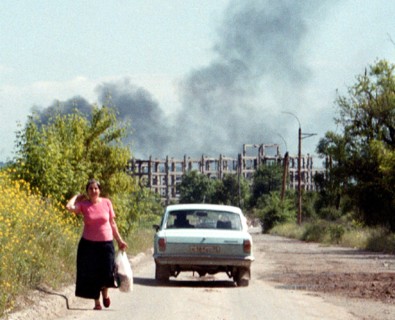 Chechnya, russia, june 16, 2001, peaceful life in grozny borders upon remaines of the war, such as a view of ruins of the chechen gas and oil insitute (on the background), a train of smoke from a burn...
