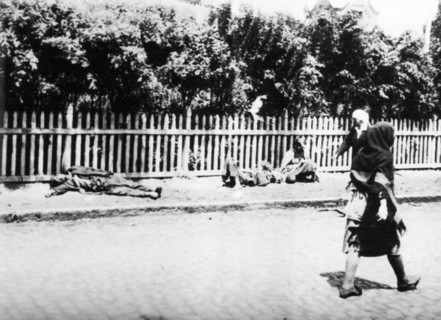 Women walk past people dying of starvation in a documentary photograph displayed at an exhibition in kiev, dedicated to holodomor, the great ukrainian famine of early 1930s.