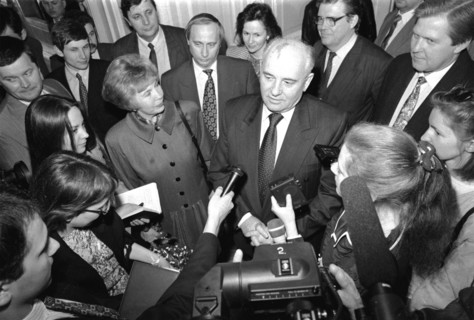 Ex-president of the ussr mikhail gorbachev and his wife raisa talking to journalists during gorbachev's visit to st,petersburg in april 1994, future president of russia, vladimir putin, is standing di...