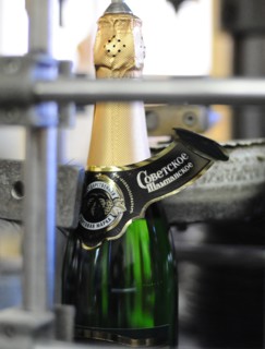 Moscow, russia, november 29, 2010, a label being applied to a bottle of sovetskoye shampanskoye on a bottling line at kornet, a moscow-based champagne winery.