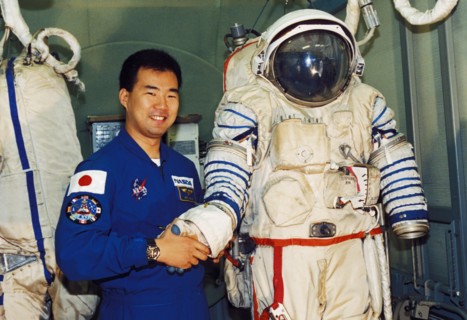 Japanese astronaut soiti noguti posing with a russian sokol spacesuit, 1998.