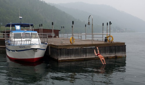 Irkutsk region, russia, july, 2011, a man diving off the pier on lake baikal's shore.