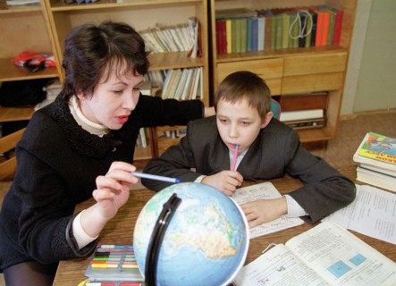 Novosibirsk,russia, january 30, 2001, picture shows a teacher marina gurgutsa explaining geography to her pupil valera savchenko in a classroom of a new orphanage opened recently in akademgorodok (the...
