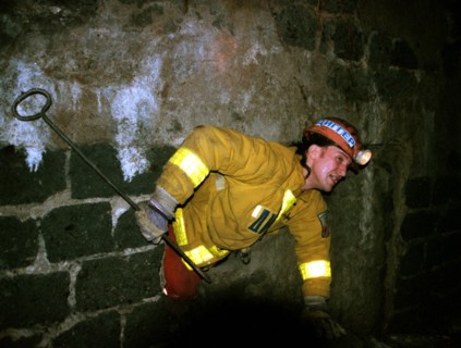A member of the 'diggers of the underground planet' club busy with a research of the municipial underground space on their own initiative pictured 'breaking through' a wall while inspecting caveries w...
