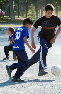 Teenagers play football in a chelyabinsk yard, russia, august 2006.