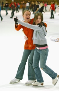 Teenagers skate on the ice rink in krylatskoye ice palace, moscow, russia, january 2007.