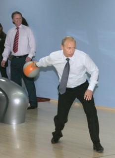 First deputy prime minister sergei ivanov (background) looks on as russian president vladimir putin bowls at the new sports complex ocean, vilyuchinsk, kamchatka, russia, september 5, 2007.