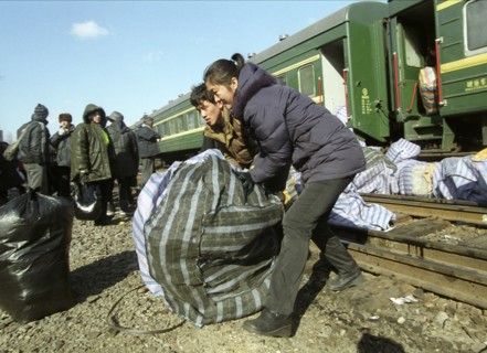 Chinese vendors disembarking a train in grodekovo with their wares, brought here to be sold in russia, maritime territory, russia, february 27 2003, the special train shuttles between chinese suifenhe...