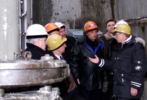 Surgut,russia, march 3 2000, acting president vladimir putin (right) wearing a helmet talks to oil workers during his visit to a drilling station near the western siberian city of surgut