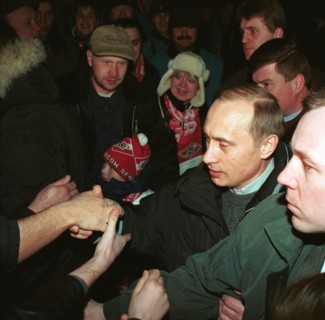 Acting president and prime minister vladimir putin (2nd from right) being greeted by football fans at moscow's luzhniki stadium on saturday when he came to watch a match between spartak moscow and ala...