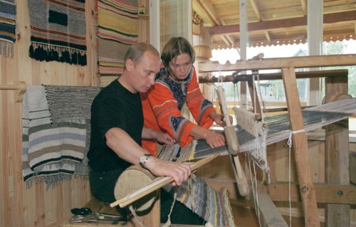 karelia, russia, august 21 2001, president vladimir putin tries his hand at weaving at the ancient loom, while visiting the ethnographic village of verkhniye mondrogi on his way to the kizhi island.
