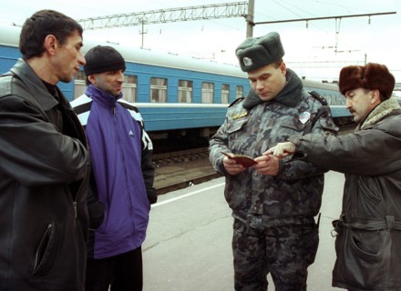 Belarus, november 12 2002: a policeman examines documents of chechen men who wish to leave for poland, at the brest railway terminal, more than 300 natives of chechnya, who are russian citizens, have ...