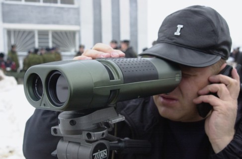 Moscow region, russia, november 15 2002: a visitor to the exhibition trying a piece of equipment for detecting optical devices in use, the demonstration was held on friday within the framework of the ...