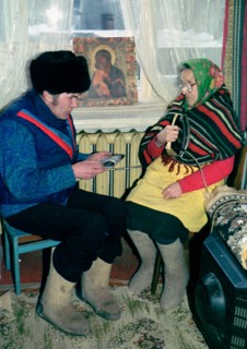 Petrozavodsk, russia, january, 16 2003: 86-year-old yevdokiya obukhovskaya (right) and her son-in-law ivan pukroyev trying to get some warmth from an iron, central steam heating and gas supply have no...