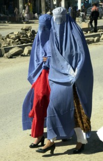 Afghanistan, march, 7 2003, afghani women wearing burkas, traditional capes with veils hiding the person, try to look attractively: from under the cape clothes corresponding to a local fashion and foo...