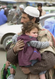 Kabul, afghanistan, march 22, 2003, a man with a child pictured in a street of kabul, servicemen of kabul security department have toughened control here, checking all vehicles arriving to the afghan ...