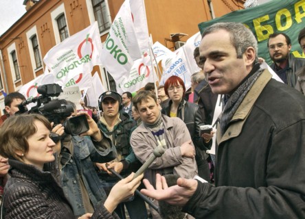 World chess champion garry kasparov (r) makes comments to the press in front of the building of moscow's meshchansky court, which postponed the announcement of the sentence on the case of former yukos...