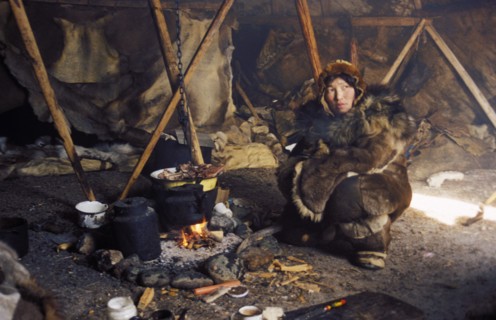 A chukchi woman in her tent cooking meat in chukotka, siberia, russia, 2000.