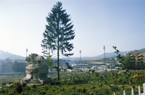 A cemetary in sarajevo, bosnia with the olympic stadium in the background, 1995.