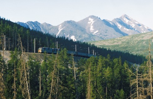 A passenger train riding along the trans-siberian railway through the kemerovo region of russia.